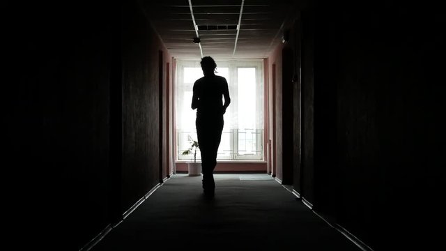 The guy walks the corridor with the phone. A man is nervous and calls someone, walks the corridor.