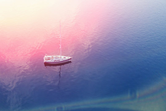 Top view of a white yacht in the blue sea in the sunlight