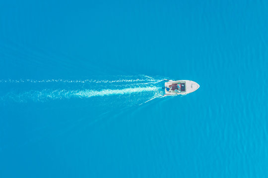 Fototapeta Top view of a white boat sailing in the blue sea