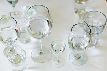 Close-up of glasses of crystal clear drinking water on a white table. Shallow depth of focus. Health concept from nature.