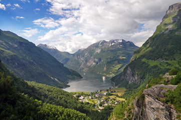 The town of Geiranger in Norway with a fjord, a deep valley and the sea.