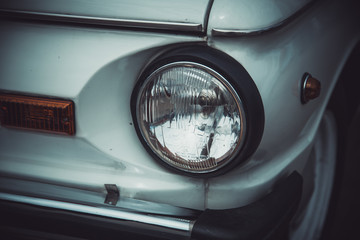 Headlights and body of an old classic car at an exhibition of vintage cars