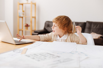 Enigmatical kid pressing the button on laptop