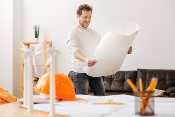 Positive delighted engineer looking at his sketch
