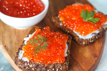 Sandwiches with red salmon caviar and rye bread.