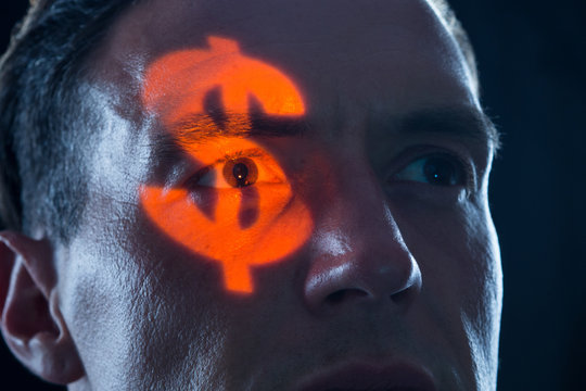 gieriger Mann mit Dollarzeichen im Auge als Symbol f&uuml;r Geld Gier und Macht