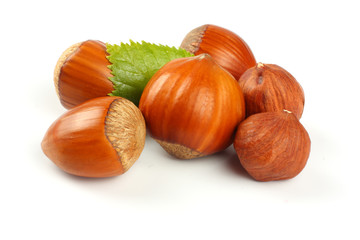 hazelnuts with green leaf isolated on white background