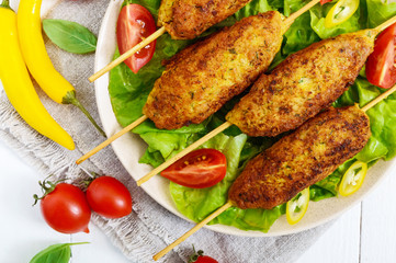 Lula-kebab is a meat dish, traditional for the Caucasus, in Central Asia and Turkey. Minced meat strung on a skewer and fried. Serve on a plate with lettuce leaves and fresh tomatoes. Close up
