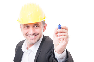 Selective focus of contractor wearing hardhat writing with marker