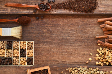 Freshly coffee beans in spoon and  ground coffee beans on table with cinnamon