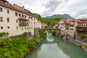 Fototapeta na wymiar The Cappuchin Bridge crossing it is the oldest preserved bridge in Slovenia. The Selca Sora river in Skofja Loka. Slovenia.