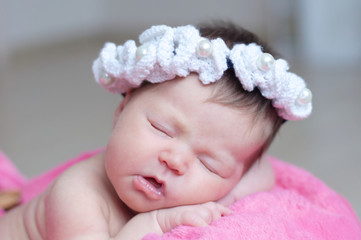 infant sleeping in basket with accessory - head band, baby girl lying on pink blanket, cute child, newborn announcement