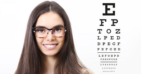 smile female face with spectacles on eyesight test chart background, eye examination ophthalmology...