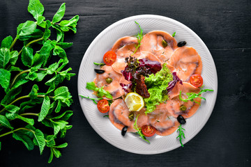 Carpaccio of fish, vegetables, cheese, spices, to Wooden background. Top view. Free space.