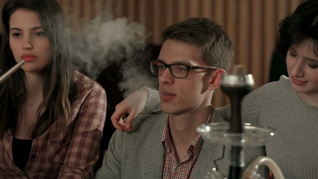 Group of young people smoking hookah in the lounge caffee