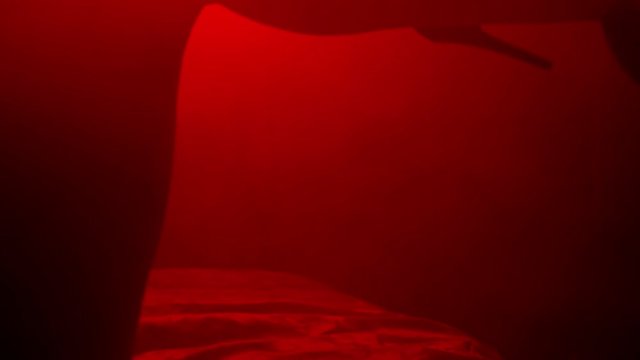 Sexy woman feets in heels shoes. Closeup of sexy female legs in shoes. Close up girl legs with slippers moving seductively. Woman shoes. Erotic concept. Sexy body in red light background