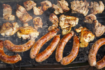 Grilled meat. Sausages on a barbecue. Grilling spiced chicken in grid on charcoal bbq.