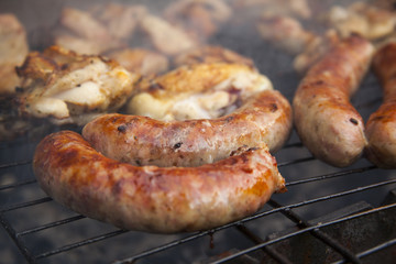 Grilled meat. Sausages on a barbecue. Grilling spiced chicken in grid on charcoal bbq.