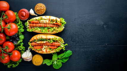 Hot dog with grilled sausage, mustard and ketchup, onions and greens on Wooden background. Top view. Free space.