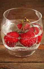 Cherries in a glass of water with bubbles