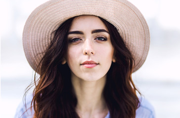 Outdoors portrait of a beautiful young woman with hat