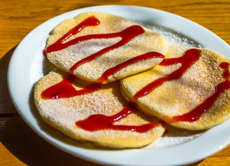 Pancakes with red raspberry topping on a plate
