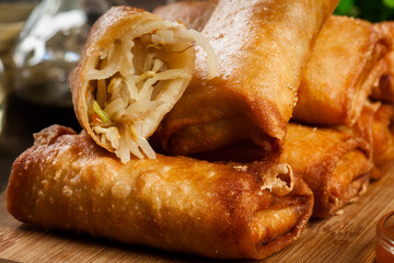 Spring rolls with chicken and vegetables on chopping board