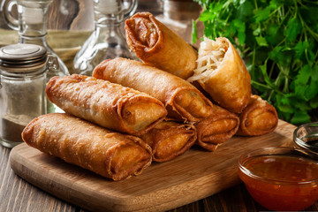 Spring rolls with chicken and vegetables on chopping board