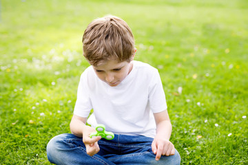School kid playing with Tri Fidget Hand Spinner outdoors