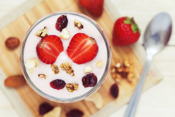 Strawberry yogurt dessert served with various nuts and fresh strawberries. Top view