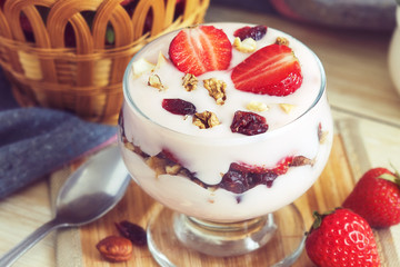 Strawberry yogurt dessert served with various nuts and fresh strawberries