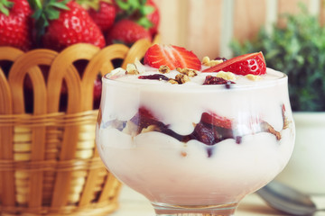 Strawberry yogurt dessert served with various nuts and fresh strawberries