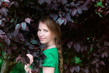 redhead cute girl in purple or brown leaves portrait