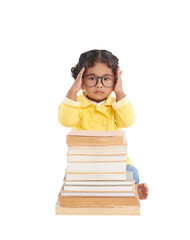 Smart toddler adjusting eyeglasses and posing for photography while sitting behind pile of shabby books, isolated on white background