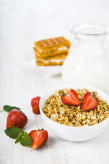 Granola with strawberry and a jug of milk
