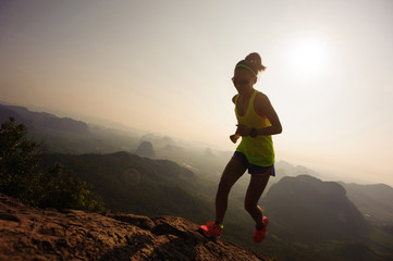 young woman running up on mountain top