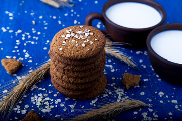 Oatmeal cookies on blue wooden background.  Towel of oat cookies with milk.