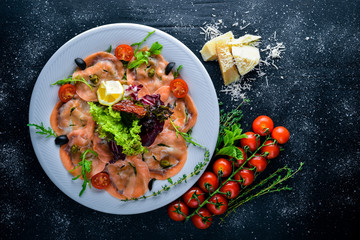 Carpaccio of fish, vegetables, cheese, spices, to Wooden background. Top view. Free space.