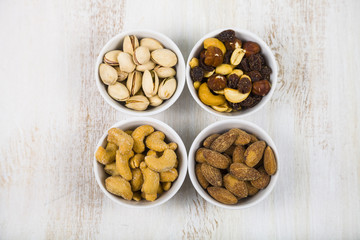 Four bowls with nuts on a  wooden table