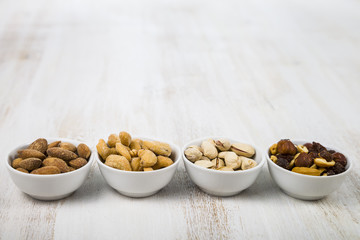 Four bowls with nuts on a  wooden table
