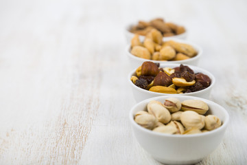 Four bowls with nuts on a  wooden table