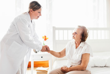 Providing care for elderly. Doctor visiting elderly patient at home.