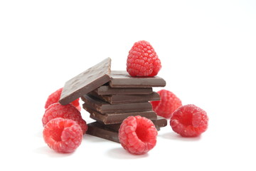 ISOLATED CHOCOLATE PIECES AND RASPBERRIES ON A WHITE BACKGROUND