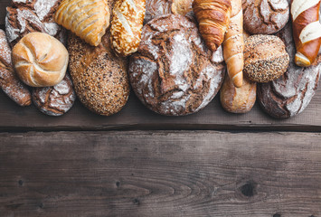 Delicious fresh bread on wooden background
