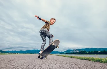 Zelfklevend Fotobehang Boy makes a trick with skateboard © Soloviova Liudmyla
