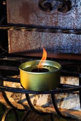 burning candle stands in wrought iron grille grill