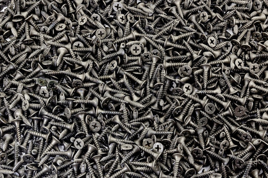 A lot of black small screws on white background