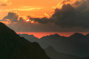 Red sunset on black rocks