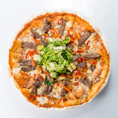 Delicious pizza with beef and salad on a light background
