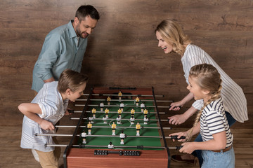 Happy smiling family playing foosball together